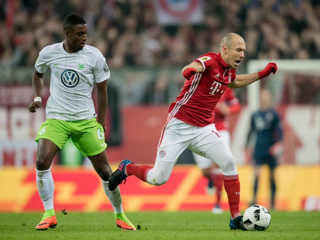 Riechedly Bazoer (l.) laat landgenoot Arjen Robben (r.) struikelen tijdens zijn debuut voor VfL Wolfsburg in het bekerduel met Bayern München. (07-02-2017)