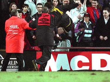 1995 springt Manchester Uniteds Éric Cantona (M.) über die Absperrung und tritt einen Fan um