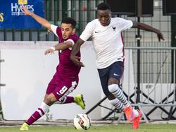 Louis Nganioni (r.) vecht een duel uit met Othman Alawi Al-Yahri tijdens een vriendschappelijk, internationaal toernooi. Frankrijk U21 neemt het op tegen Qatar U21. (29-05-2015) 