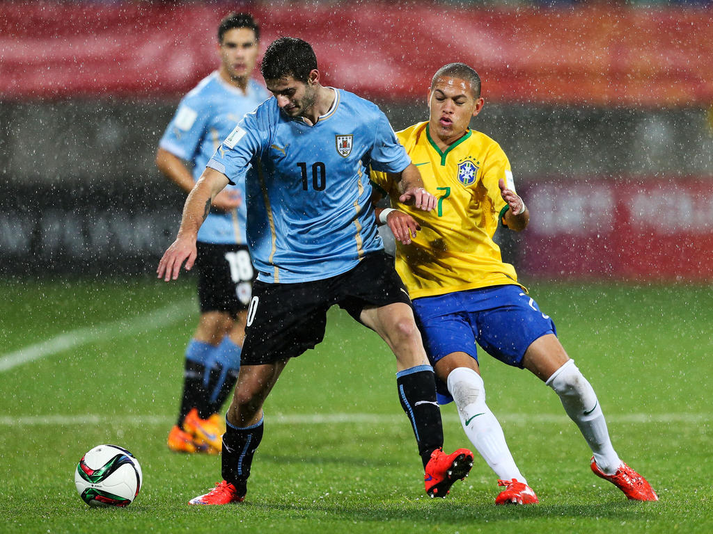 Gáston Pereiro (l.) vecht tijdens het WK u20 namens Uruguay een duel uit met Braziliaan Marcos Guilherme. (11-06-2015)