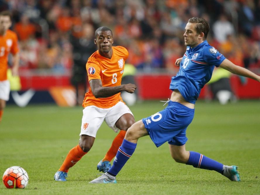 Gylfi Sigurðsson (r.) passt de bal naar een medespeler op het middenveld. Georginio Wijnaldum (l.) is te laat om de bal te onderscheppen tijdens de wedstrijd tussen het Nederlands elftal en IJsland. (03-09-2015)