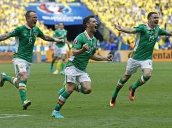 Wes Hoolahan (m.) heeft Ierland zojuist met een harde knal op een 1-0 voorsprong geschoten tegen Zweden tijdens het EK. Glenn Whelan (l.) en Robbie Brady (r.) vieren het feestje met de doelpuntenmaker mee. (13-06-2016)