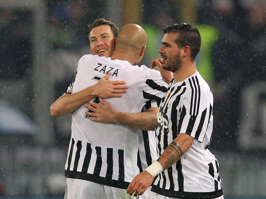 Stephan Lichtsteiner (l.) heeft zojuist gescoord voor Juventus tegen Lazio Roma in de kwartfinale van de Coppa Italia. De Zwitser wordt gefeliciteerd door Simone Zaza (m.) terwijl Stefano Sturaro ook het feestje meeviert.