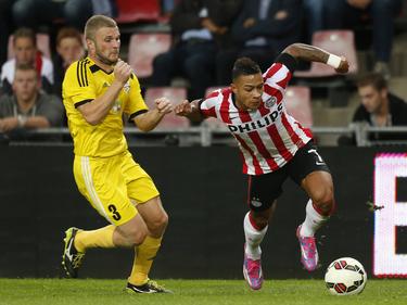 Memphis Depay (r.) is Siarhei Matveichyk (l.) te snel af tijdens PSV - Shakhter Soligorsk. (21-08-2014)