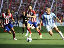 Nordin Amrabat (r.) kijkt over de bal heen in het duel tegen Atlético Madrid. Miranda (l.) en Juanfran kunnen niet ingrijpen, (11-05-2014)
