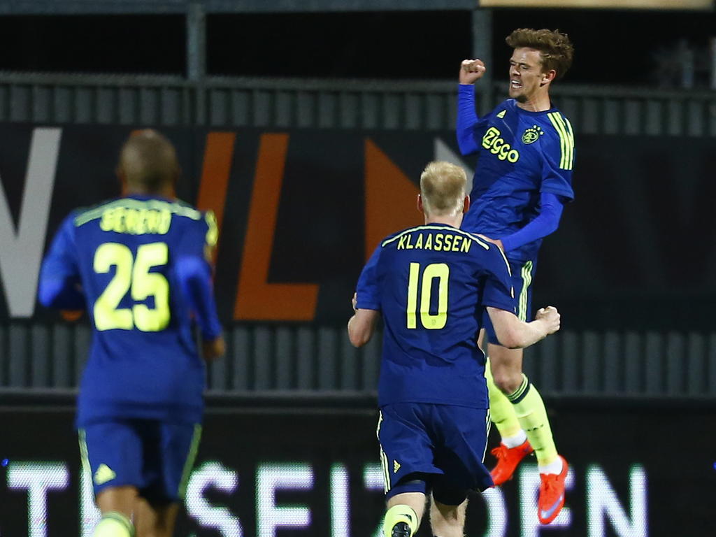 Lucas Andersen (r.) scoort de bevrijdende 2-0 tegen Heracles Almelo, waardoor Ajax de drie punten kan bijschrijven. Davy Klaassen (m.) en Thulani Serero zijn op weg naar het feestje. (11-04-2015)