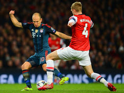 Arjen Robben (l.) probeert Per Mertesacker (r.) te passeren tijdens Arsenal - Bayern München. (19-2-2014)