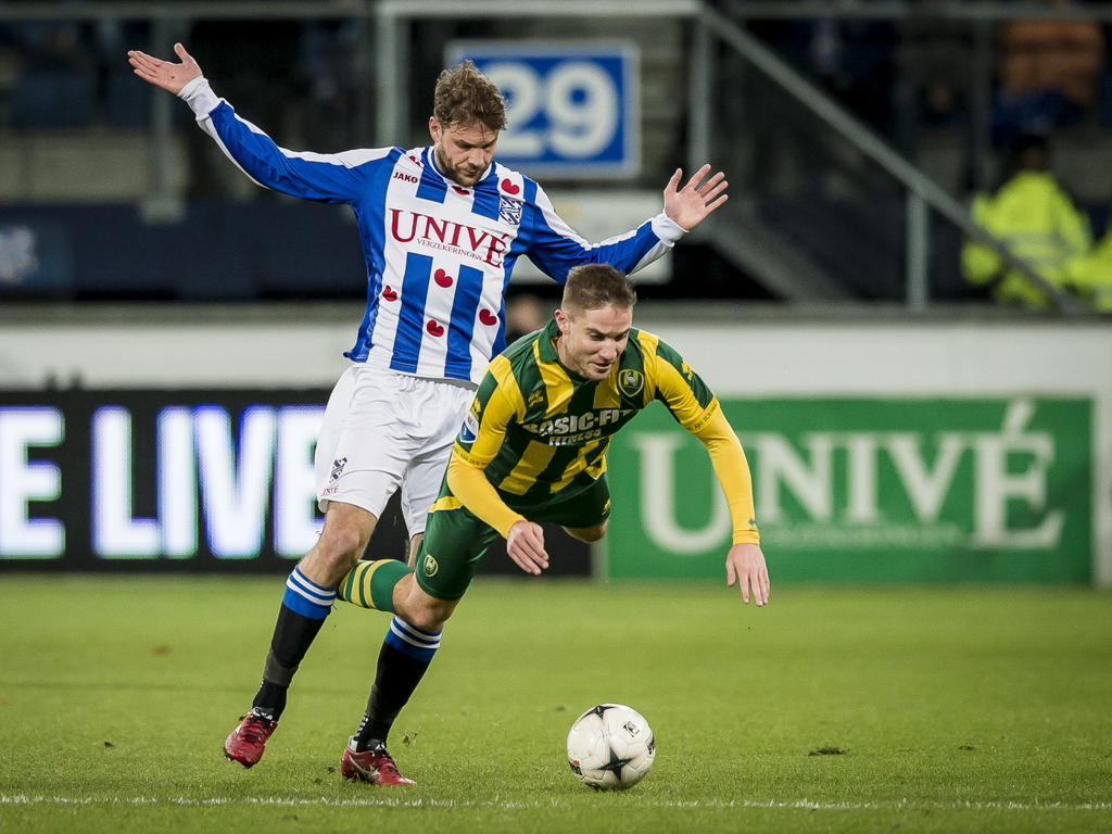 Aaron Meijers (voor) gaat naar de grond na in contact te zijn gekomen met Joey van den Berg (achter) tijdens sc Heerenveen - ADO Den Haag. (19-12-2014).