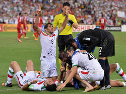 Reza Ghoochannejhad wird von seinen Teamkollegen begraben: Soeben hat er den Iran zum 1:0-Last-Minute-Sieg gegen die VA Emirate geschossen.