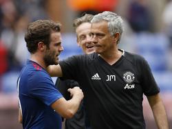 Een onderonsje tussen Juan Mata (l.) en José Mourinho (r.) na afloop van het oefenduel van Manchester United met Wigan Athletic. (16-07-2016)