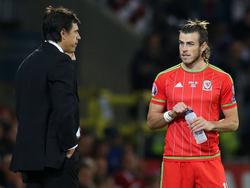 Bondscoach Chris Coleman (l.) voert topoverleg met Gareth Bale (r.) tijdens het EK-kwalificatieduel Wales - Andorra. (13-10-2015)