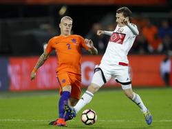Rick Karsdorp (l.) speelt de bal door de benen van de Wit-Rus Mikhail Gordeychuk (r.) tijdens zijn debuut voor het Nederlands elftal. (07-10-2016)