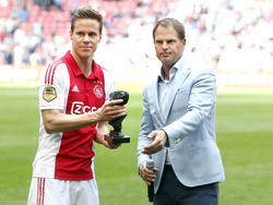 Niklas Moisander (l.) neemt afscheid van Ajax na het duel met SC Cambuur. Hij ontvangt een beeld van trainer Frank de Boer (r.). (10-05-2015)