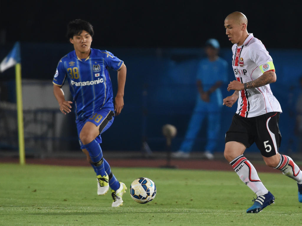 Ritsu Doan (l.), de aanvaller van Gamba Osaka, maakt zijn debuut voor de Japanse ploeg. Rechts dribbelt Cha Du Ri op met de bal. (27-05-2015)