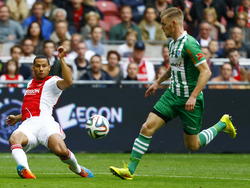 Ricardo van Rhijn (l.) zet al vallend de bal voor in de competitiewedstrijd tegen PEC Zwolle. Maikel van der Werff is te laat. (05-10-2014)