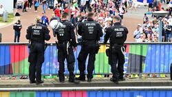 Einsatzkräfte der Polizei beobachten Fußballfans auf einem Fanfest
