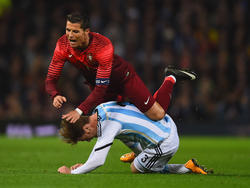 Argentijn Christian Ansaldi (onder) geeft de Portugese sterspeler Cristiano Ronaldo vliegles en moet dat bekopen met een gele kaart. (18-11-2014)