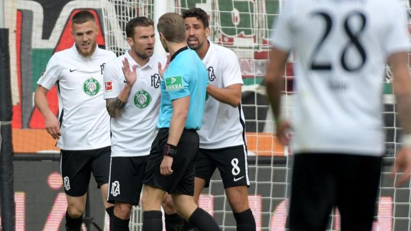 Die FCA-Profis diskutieren mit Schiedsrichter Tobias Welz über eine Elfmeterszene