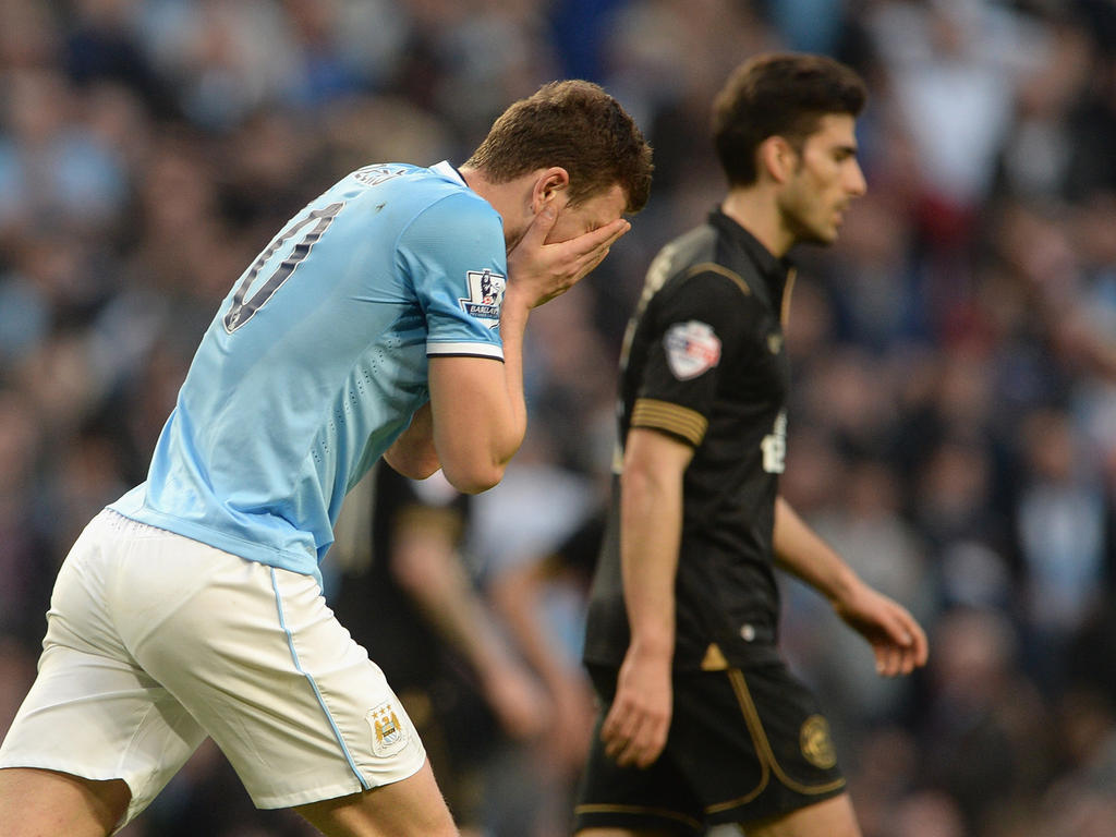 Edin Džeko (l.) baalt van een grote misser en voelt de bui al hangen. Voetbal.com Foto van de Week. (9-3-2014)