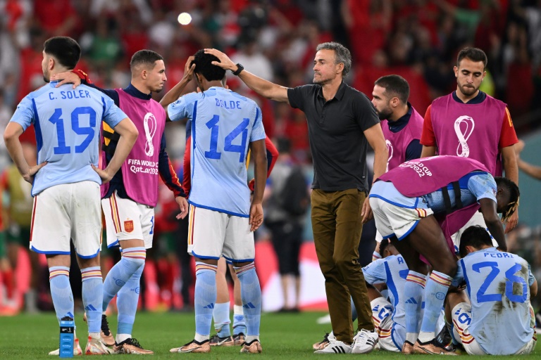 Spain's coach Luis Enrique (C) consoles Spain defender Alejandro Balde after they lost against Morocco