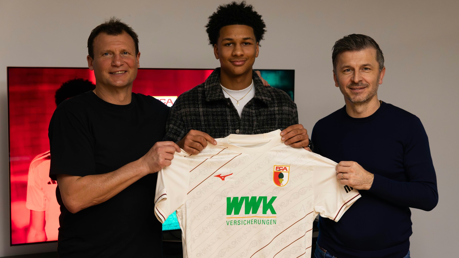 Kevin Nana Motowilczuk (Mitte) mit dem FCA-Trikot