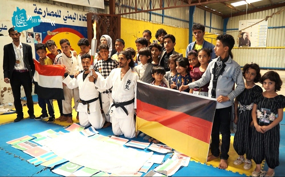 Nashwan mit Fackel und Deutschland-Fahne in der Hand Nashwan mit Fackel und Deutschland-Fahne in der Hand