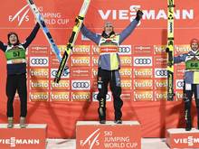 Karl Geiger (m.) feiert seinen 13. Weltcupsieg